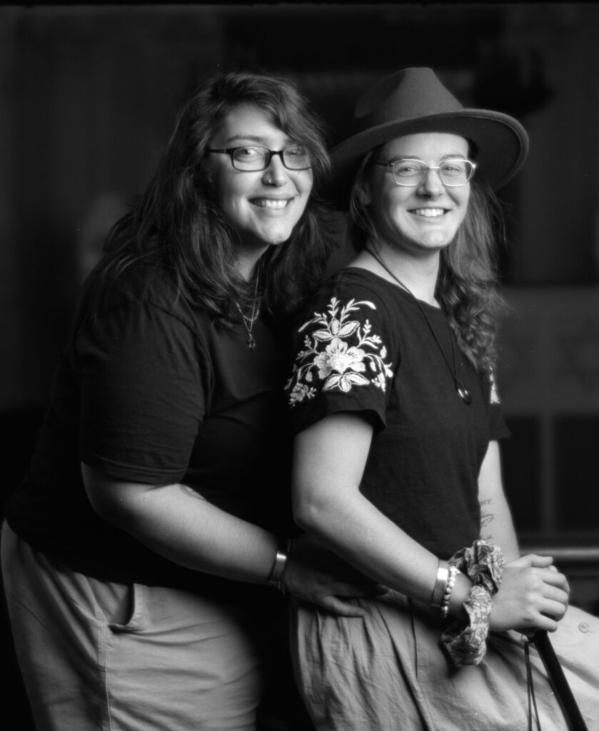 Black and white photo of two people smiling at the camera