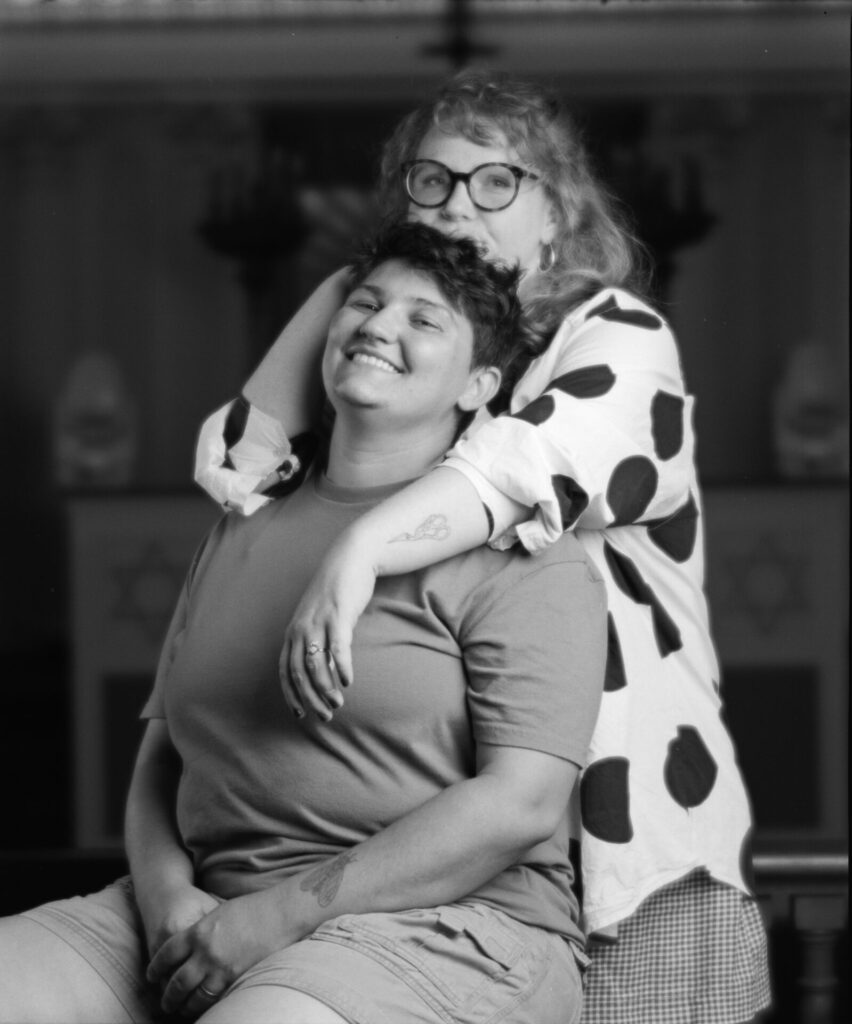 Black and white photo of two people smiling at the camera