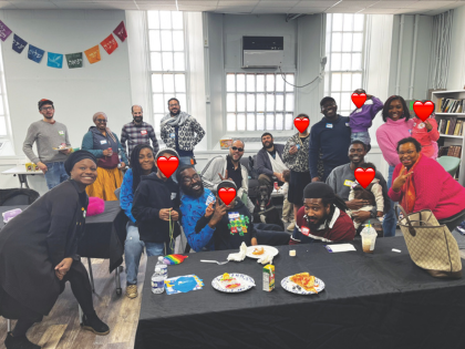 A large group of Black Jews and other BIPOC Jews and their loved ones pose in the Third Space beit midrash