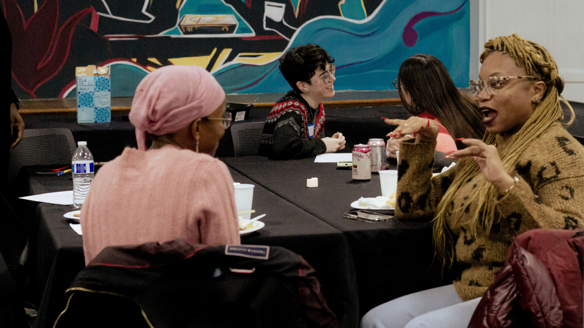 People sit and talk around a table.